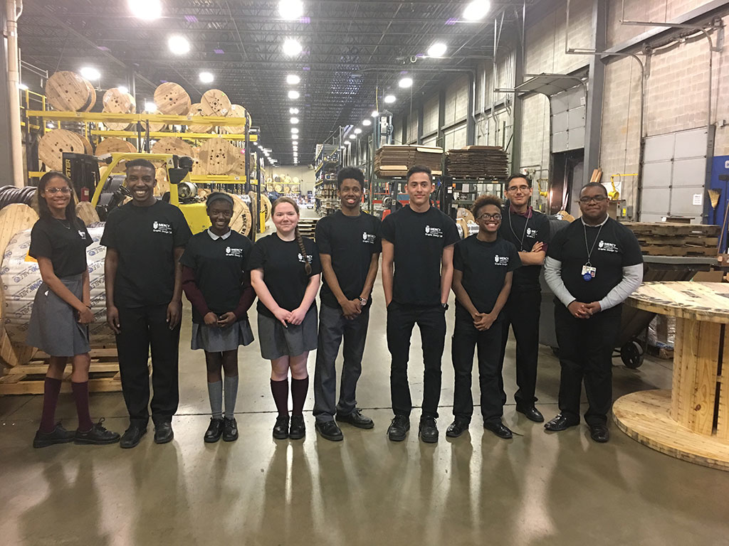 Nine students from Mercy Career amp Technical High Schoolrsquos Mercy CTE junior class Graphic Design program competed to develop a secondary logo for Omni Cable Winner Roberto Rodriguez second from the right won 2000 in tuition assistance